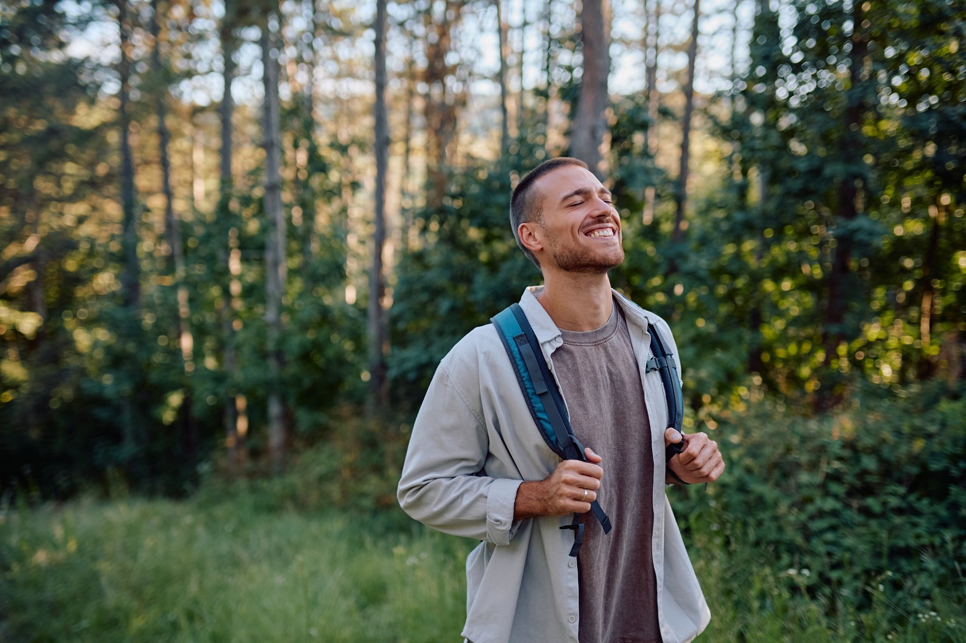 Happy hiker breathing in fresh air while enjoying a trekking day in the serene woods